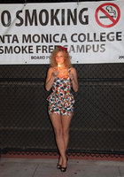 Кудрявая модель прогуливается по улице и позирует 1 фото